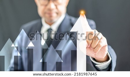 Businessman wearing a black suit pointing arrow up interest finance banking, economy, stock, market, oil, gas, petroleum, concept, selective focus, close-up Copy space on right. black, blur background
