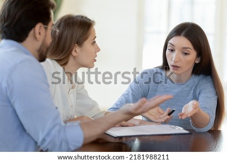 We shall complain to your superiors. Angry worried annoyed young family couple customers clients dissatisfied with bad unfair contract conditions, arguing with agent consultant lawyer prove their case Royalty-Free Stock Photo #2181988211