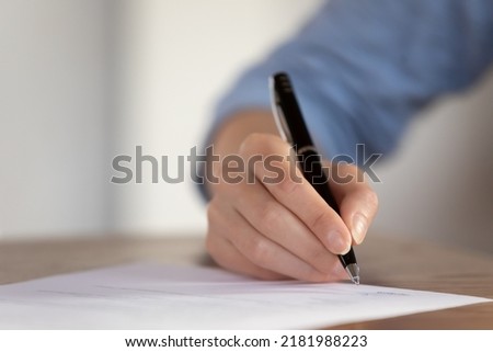 Concluding a contract. Close up of young female client or customer hand with pen ready to sign paper document or business letter, mortgage or loan application, rental or tenancy agreement. Copy space Royalty-Free Stock Photo #2181988223