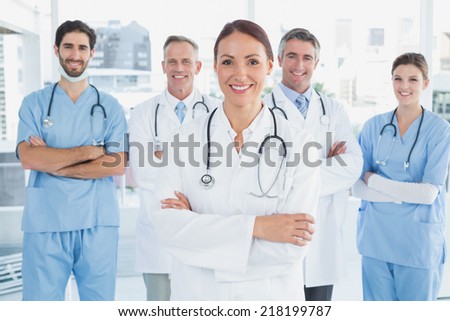 Smiling doctor with fellow doctors standing behind her Royalty-Free Stock Photo #218199787