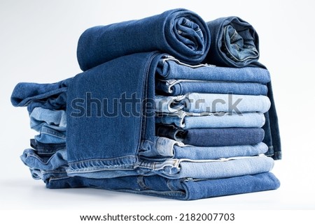 Jeans trousers stack on white background in supermarket and store. business jeans concept. Royalty-Free Stock Photo #2182007703