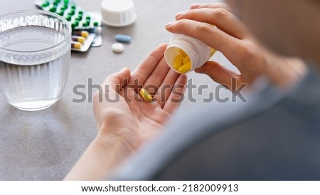 Close up woman holding pill in hand with water. Female going to take tablet from headache, painkiller, medication drinking clear water from glass. Healthcare, medicine, treatment, therapy concept Royalty-Free Stock Photo #2182009913