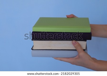 Books in the hands of a young beautiful girl