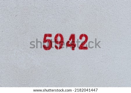 Red Number 5942 on the white wall. Spray paint.
