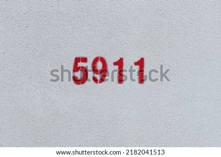 Red Number 5911 on the white wall. Spray paint.
