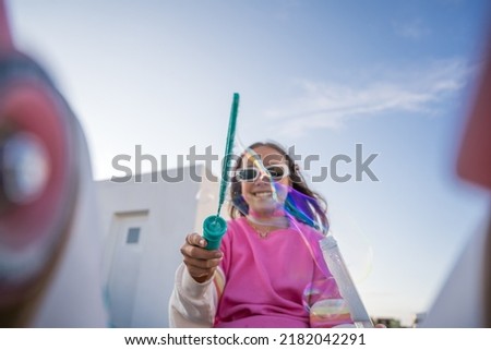Lovely caucasian girl blowing soap bubbles and enjoying of the summer while playing