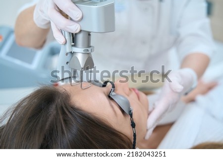 Woman undergoing a procedure for removing neoplasms with a laser Royalty-Free Stock Photo #2182043251