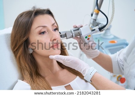 Procedure for laser removal of neoplasms on the face in a cosmetology clinic Royalty-Free Stock Photo #2182043281