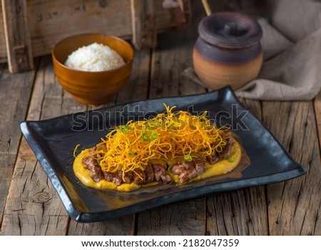 RIBEYE Steak IN APPLE SAUCE served in a dish isolated on wooden background side view of steak