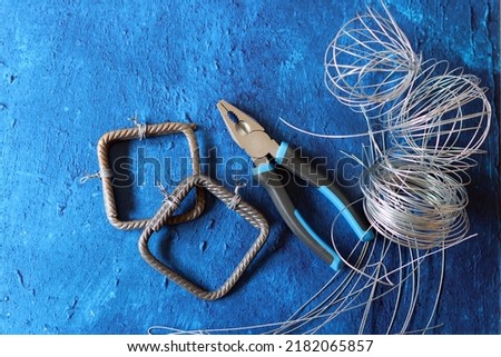 Tools on blue textured background with copy space. Vintage pliers close up photo. Handyman tools top view photo. 