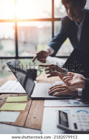 Business people consulting and planning and analyzing marketing on laptop computer in office.