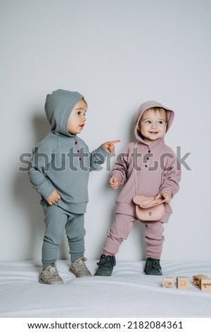 Baby fashion. Unisex gender neutral clothes for babies. Two Cute baby girls or boys in cotton set Royalty-Free Stock Photo #2182084361