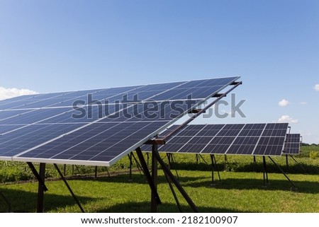  Solar panels on the background of a blue cloudy sky. Solar power plant. Blue solar panels. An alternative source of electricity. Solar farm in the field. High quality photo