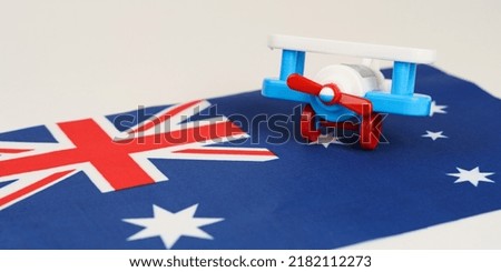 A toy plane stands on the flag - Australia. Travel and business concept