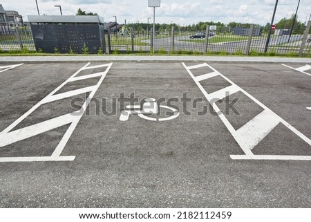 Reserved disable parking sign on the asphalt road surface.