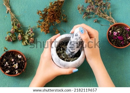 Grinding of dry herbs in mortar. Various dried meadow herbs and herbal tea. Dried and fermented plants for delicious drinks, herbal medicine and health promotion