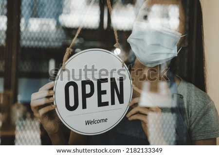 asian waitress staff woman wearing protection face mask turning open sign board on glass door in modern cafe coffee shop, cafe restaurant, retail store, small business owner, food and drink concept