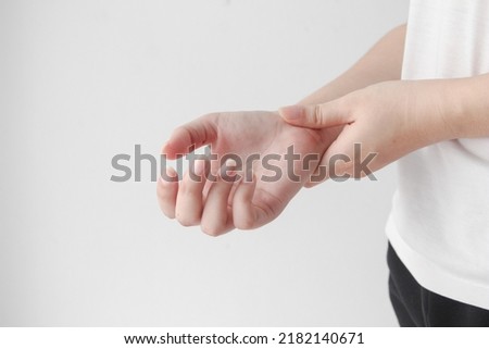 Young female suffering from pain in hands and massaging her painful hands. hurt include carpal tunnel syndrome, fractures, arthritis or trigger finger, Peripheral neuropathy. Royalty-Free Stock Photo #2182140671