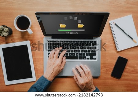 Transfer files data system relocation concept, Person hand using laptop computer waiting for transfer file process with loading bar icon on virtual screen. Royalty-Free Stock Photo #2182142793