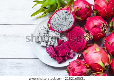 fresh white and pink red purple dragon fruit tropical in the asian thailand healthy fruit concept, dragon fruit slice and cut half on white plate with pitahaya background