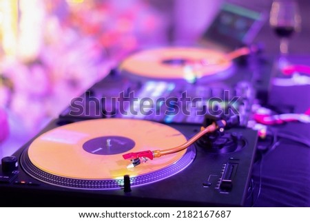 A DJ table with 2 turntables and 1 mixer at the wedding After party. Royalty-Free Stock Photo #2182167687