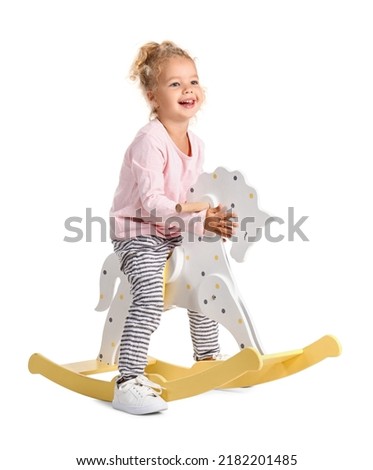 Adorable little girl with rocking horse on white background Royalty-Free Stock Photo #2182201485
