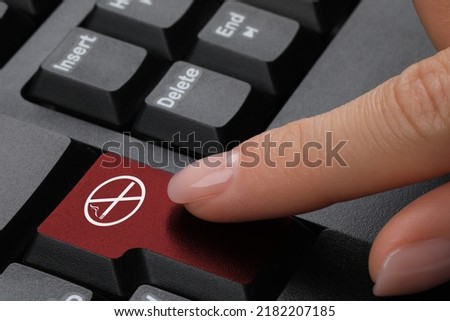 Woman pressing red button with sign No Smoking on computer keyboard, closeup