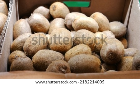 Close-up of many ripe kiwis in a trading box