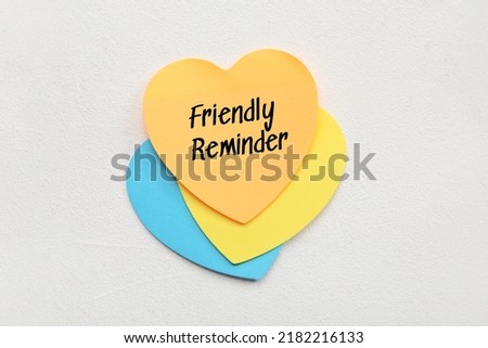Heart shaped sticky note with text FRIENDLY REMINDER on light background Royalty-Free Stock Photo #2182216133