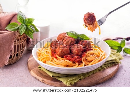 Eating Spaghetti and beef Meatballs with tomato sauce in white dish on wooden rustic board, Italian-American food. Royalty-Free Stock Photo #2182221495