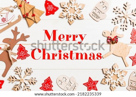 Merry Christmas text. Top view of Christmas decorations and toys on wooden background. Copy space. Empty place for your design. New Year concept.