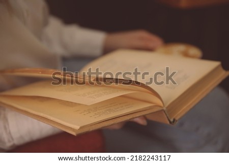 Woman reading book in room, closeup view