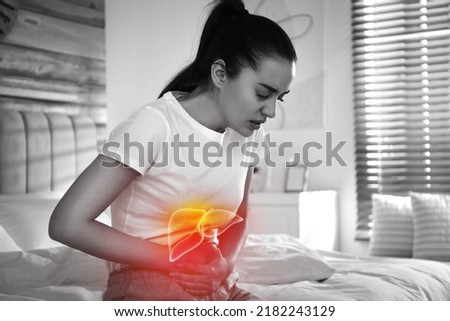 Sick woman suffering from pain in bedroom and illustration of unhealthy liver. Hepatitis disease Royalty-Free Stock Photo #2182243129