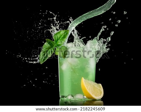 Gin basil smash cocktail splash on black background