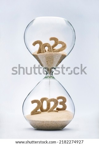 New Year 2023 concept with hourglass falling sand taking the shape of a 2023 Royalty-Free Stock Photo #2182274927