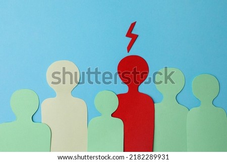 Paper cutout of crowd with one human silhouette different from others on light blue background, flat lay. Emotional management Royalty-Free Stock Photo #2182289931
