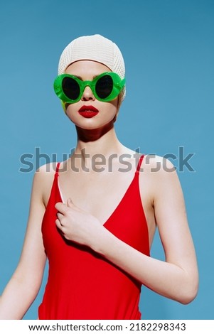 Surprised swimmer in glasses swimming cap on a blue background