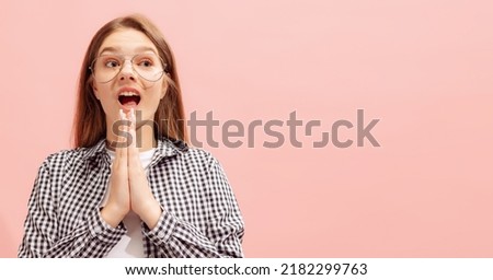 Portrait of young girl posing in glasses and checkered shirt isolated over pink background. Looks shocked. Concept of beauty, style, lifestyle, youth, emotions, facial expression. Copy space for ad
