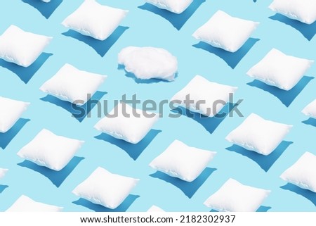 Pattern made of white pillows and one cotton cloud on serenity pastel blue background. Sleeping concept. Isometric flat lay. Break the pattern. Royalty-Free Stock Photo #2182302937