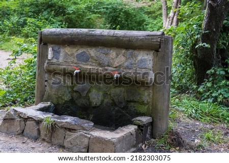 Fountain in park with stone wall plastic faucet
