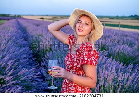 Beautiful blonde woman posing for pictures outdoors in a picturesque lavender field.