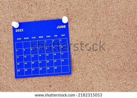June 2023 blue calendar with pin on cork bulletin billboard. Copy space, Royalty-Free Stock Photo #2182315053