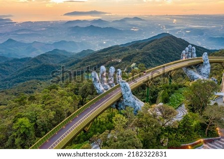 Aerial view of the Golden Bridge is lifted by two giant hands in the tourist resort on Ba Na Hill in Da Nang, Vietnam. Ba Na mountain resort is a favorite destination for tourists Royalty-Free Stock Photo #2182322831