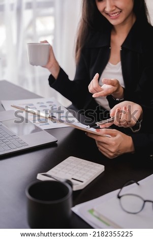 The financiers are calculating personal taxes for their customers. Royalty-Free Stock Photo #2182355225