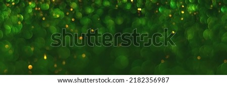Green and golden sparkling glitter bokeh background, texture. Holiday lights. Abstract defocused header. Wide screen wallpaper. Panoramic web banner with copy space for design