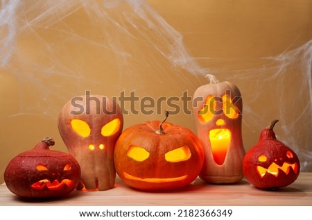 Halloween pumpkins with burning mouths on orange background