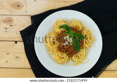 Spaghetti Bolognese with minced beef, onion, chopped tomato, garlic, olive oil, stock cube, tomato puree and Italian herb. Traditional Italian food in white plate

