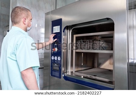 Man sterilising hospital material with a sterilisation machine Royalty-Free Stock Photo #2182402227