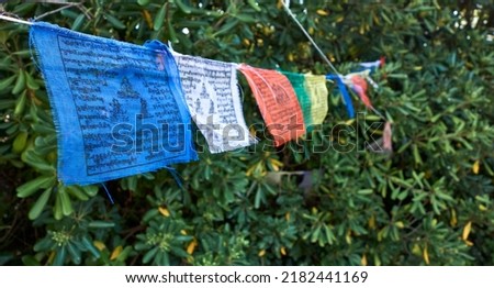 Detail of some colored Tibetan prayer flags hanging on a rope Royalty-Free Stock Photo #2182441169