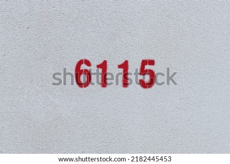 Red Number 6115 on the white wall. Spray paint.

